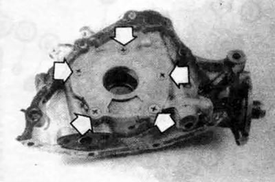 14.7. На крышке масляного насосе двигателя 1,5 л отвинтите винты (стрелки) и снимите крышку…