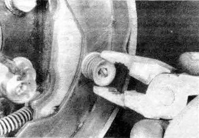 6.4f. Снимите фиксирующие пружины колодок с каждой колодки, при этом нажмите вниз на колпачок…