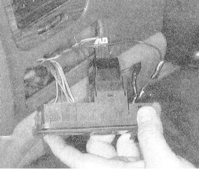 2. Поддев отверткой или другим подходящим инструментом, отпустите расположенные по бокам сборки…