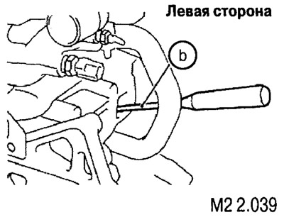 Введите в отверстие отвертку или ключ (b) подходящего диаметра для фиксации вала и ослабьте винт…